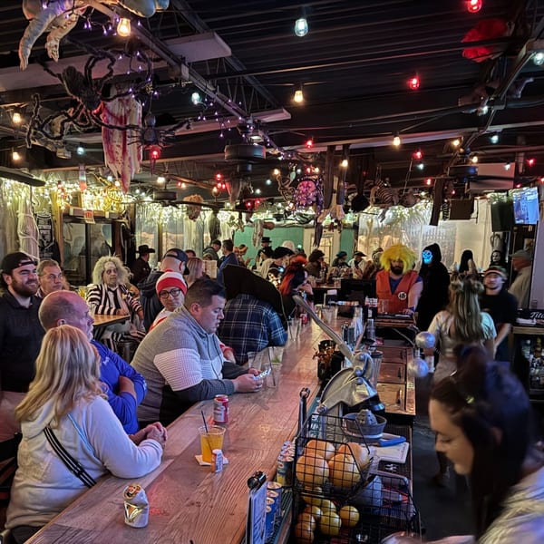 Patrons in Halloween costumes enjoying drinks at the Salted Rim Margarita Bar & Grille.