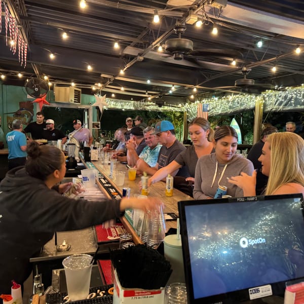 A lively bar scene at The Salted Rim Margarita Bar & Grille with patrons enjoying drinks.