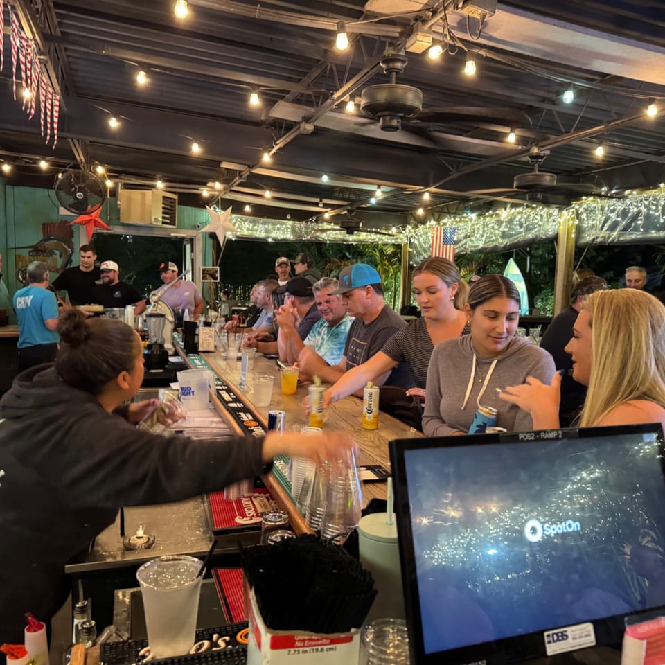 A lively bar scene at The Salted Rim Margarita Bar & Grille with patrons enjoying drinks.