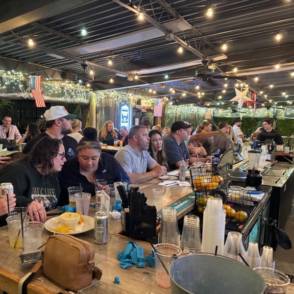 Patrons enjoying drinks and food at the lively bar of The Salted Rim Margarita Bar & Grille.